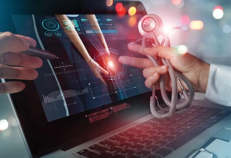 abstract lights indicating data anaytics float around a laptop and stethoscope