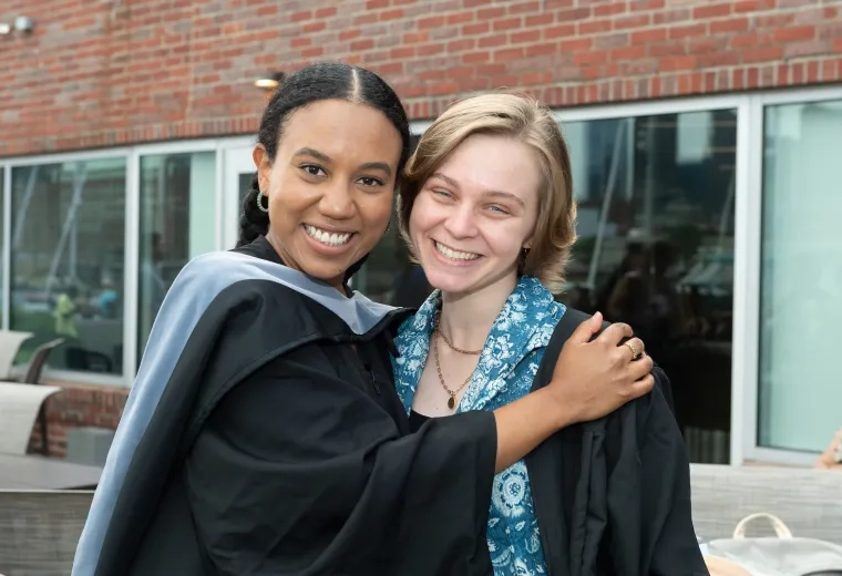 women hugging with graduation robes on