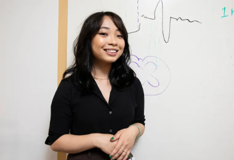 lab student in front of white board graphs