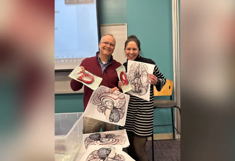 two people holding paper and pipe cleaners