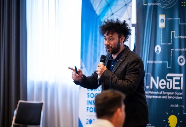Man speaking to crowd with microphone 