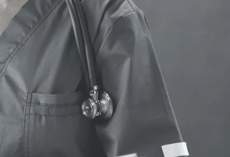 person in scrubs holds a clipboard