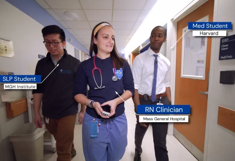 3 people walk down a hallway together, noted to be a SLP Student grom MGH IHP, an RN Clinician from MGH, and a med student from Harvard