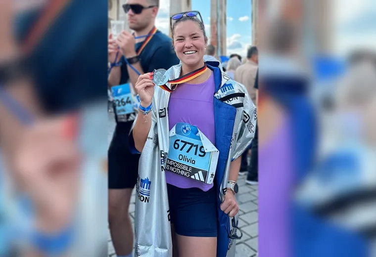 woman holding marathon medal 