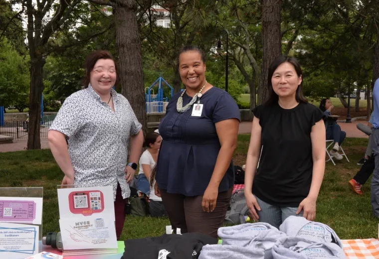 A photo of three women smiling at the camera.