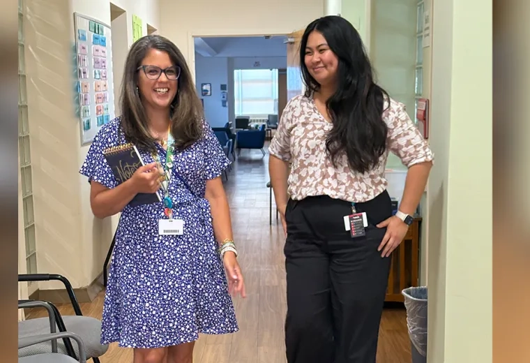 two women walking in hallway 