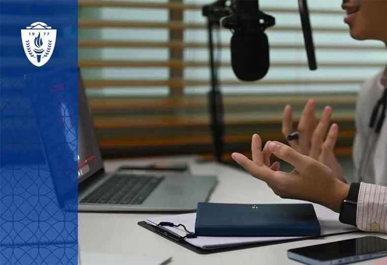 Doctor sitting at desk in front of a laptop and talking into a microphone