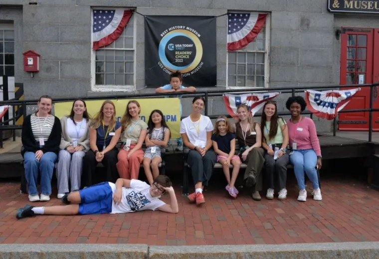 Group of people posing on a bend in from of a brick building 