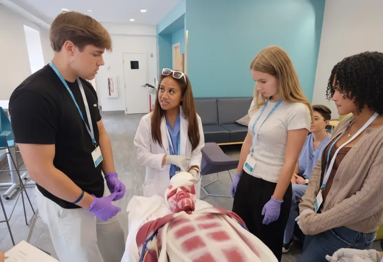 young adults stand around a plastic replica of the inside of a body