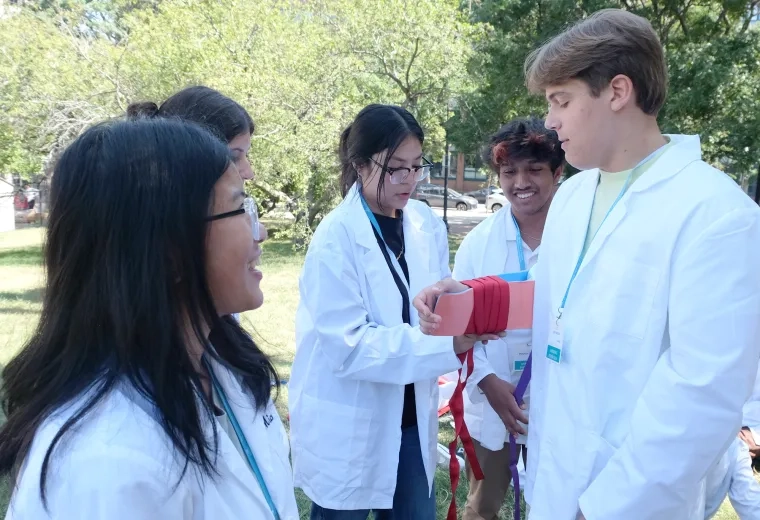 students wrap another student's arm in a splint