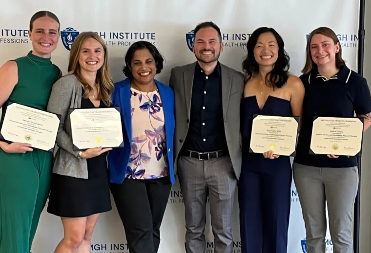 Six people stand together with four of them holding certificates