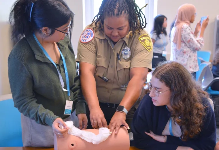students work on a torso with EMS personnel 