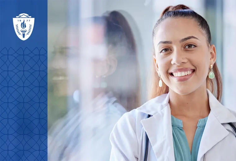 Headshot of woman wearing white lab coat and stethoscope smiling and looking at the camera
