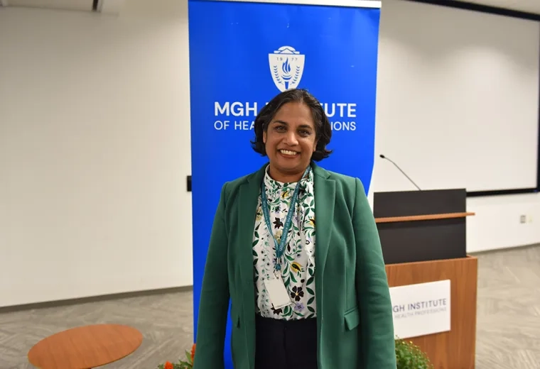 A woman stands in front of a blue banner