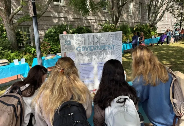 the back of 4 girls' heads reading a poster board