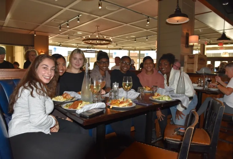 Seven women sit around a table at a restaurant