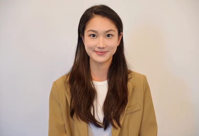 Headshot of womand with long dark hair wearing a white shirt and light brown jacket