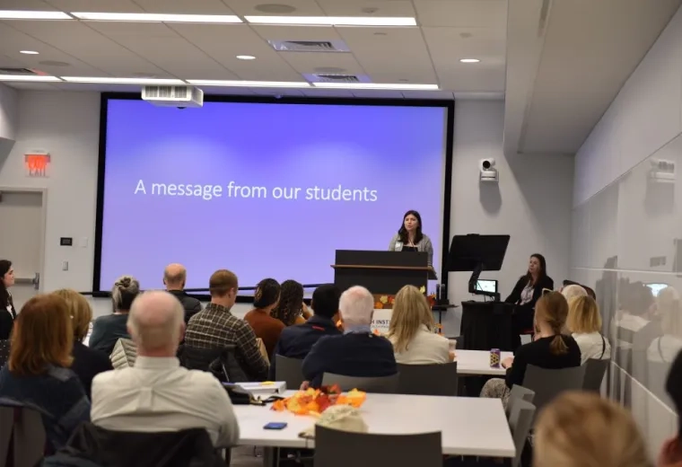 A women speaks to an audience from a podium 