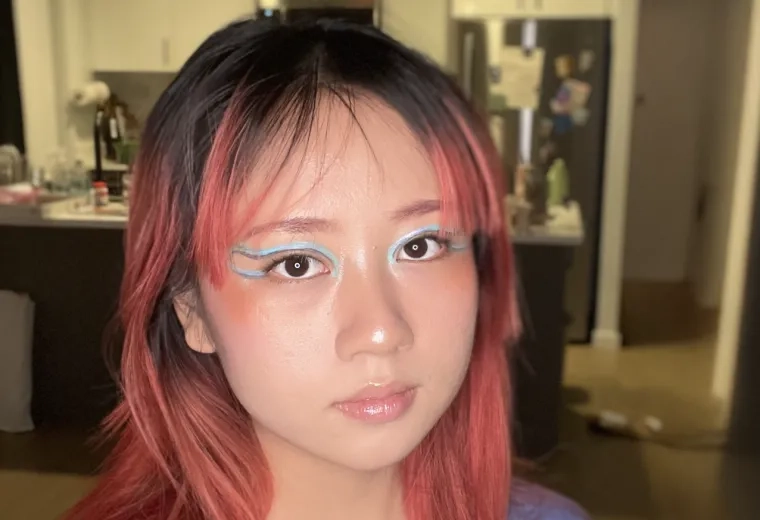 Headshot of Woman with dyed red hair wearing a blue shirt