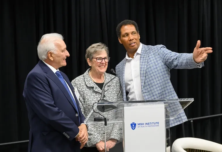 Three people stand behind a podium