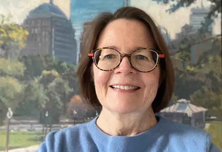 Photo of woman with dark hair wearing glasses and a blue shirt
