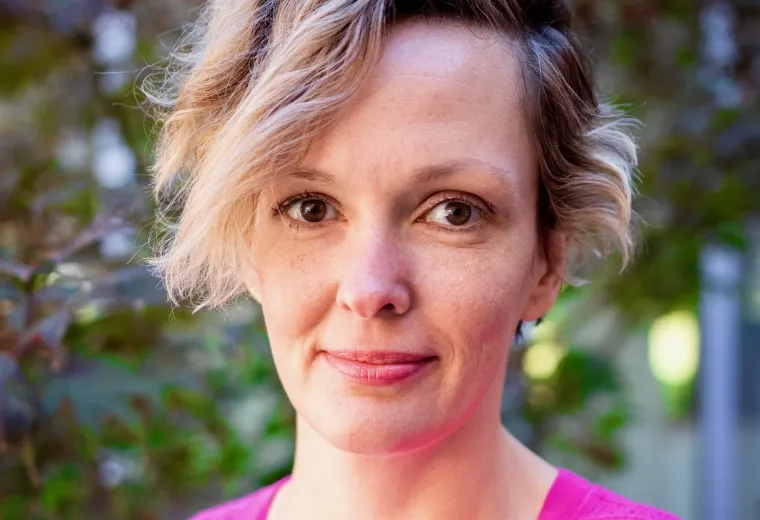Headshot of woman with blond hair wearing pink sweater