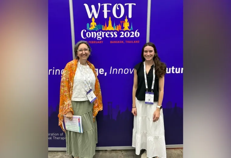 Two women standing in front of a backdrop with WFOT Congress 2026 Printed on it