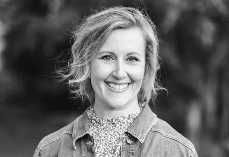 Black and white headshot of woman with shoulder length hear wearing a denim jacket