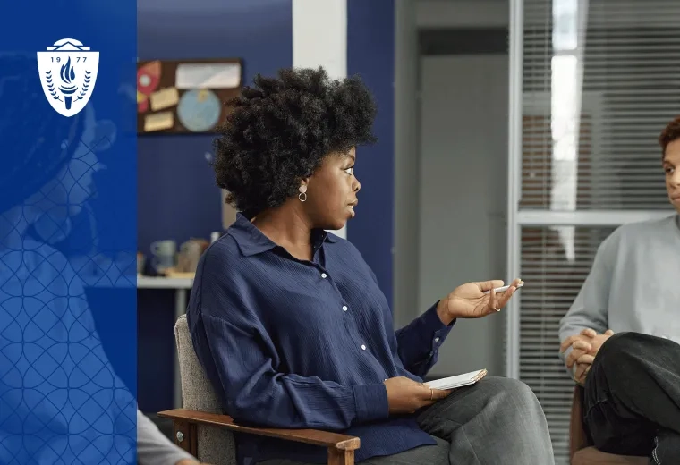 Two people sitting in charis next to each other in office