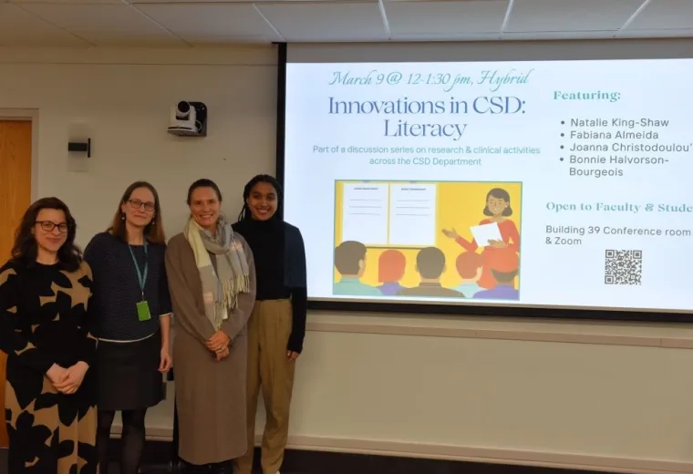 4 women standing left of a screen