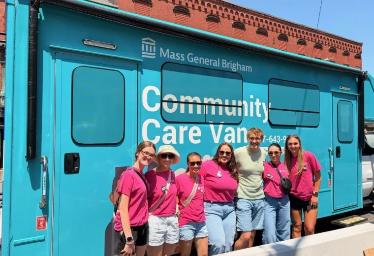 Occupational Therapy students pose in front of a community care van at a Disability Pride event in Chelsea