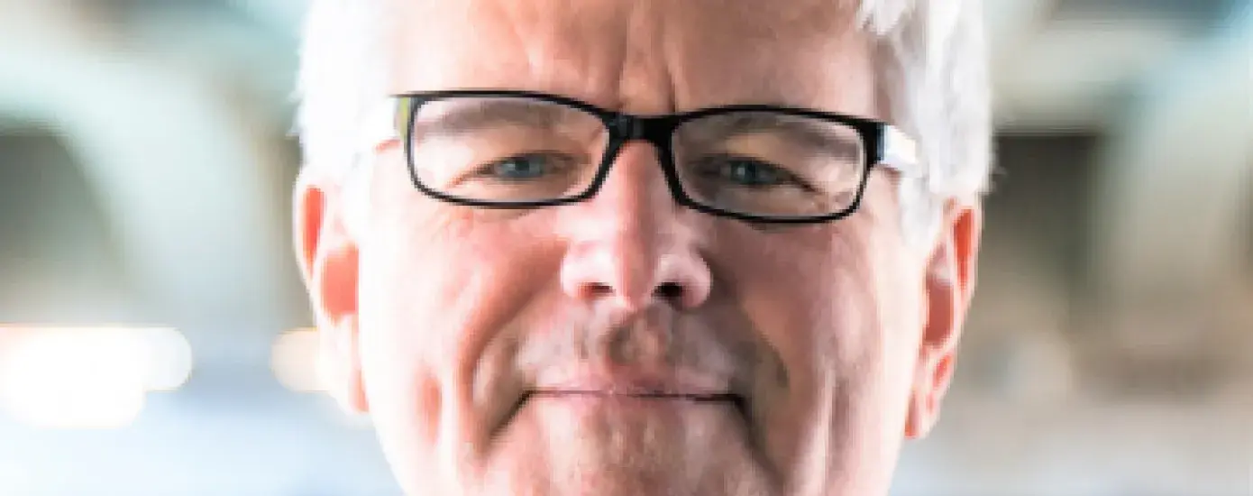 Peter brown in the center with a blurry background.