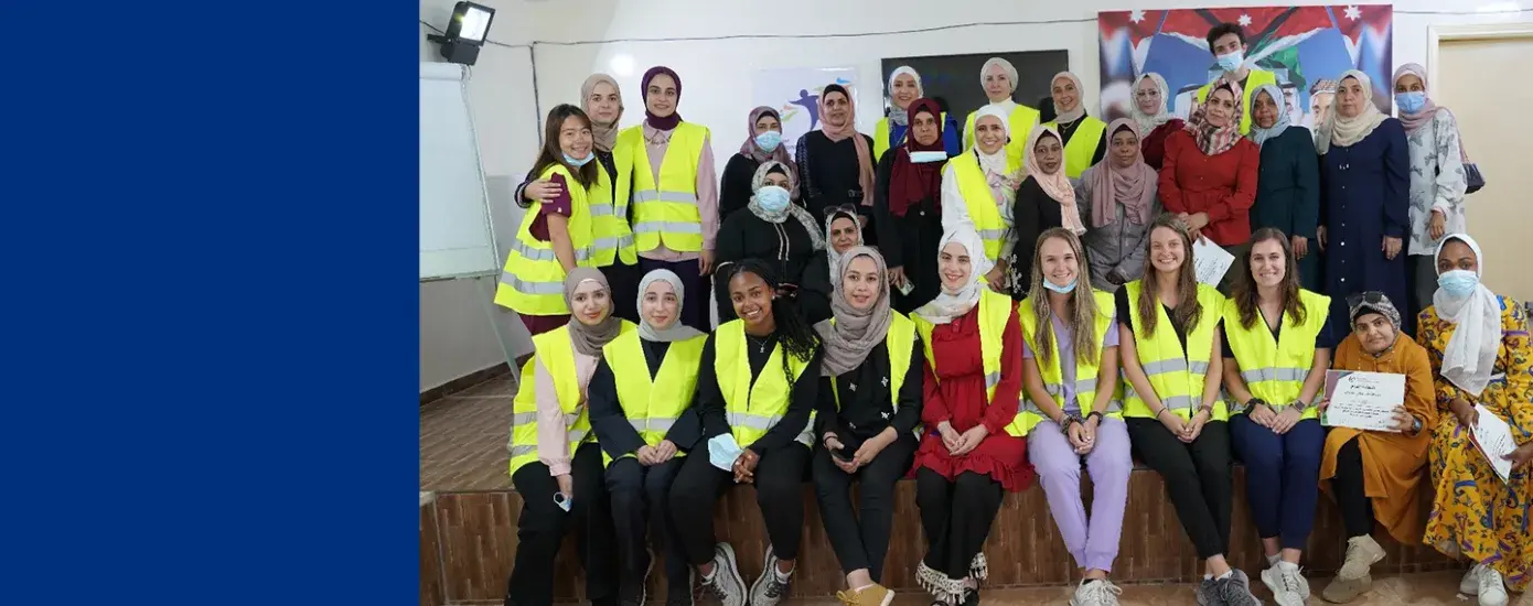 group of women some wearing hijabs some wearing yellow vests
