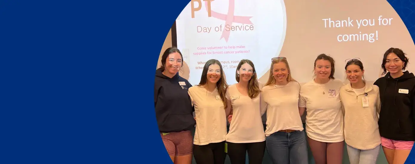 group of students in front of a projection that says thank you for coming with a pink cancer ribbon