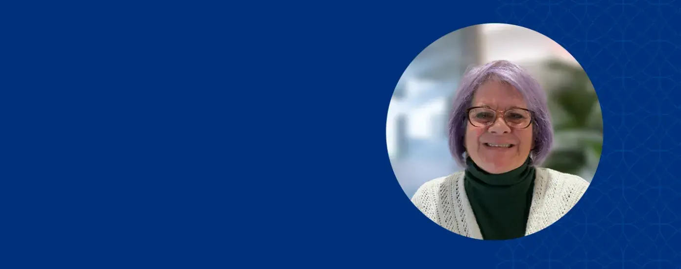 paula has purple hair and dark red rimmed glasses