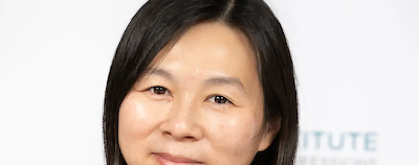 kim has a mottled black cowl neck shirt on and is Asian presenting