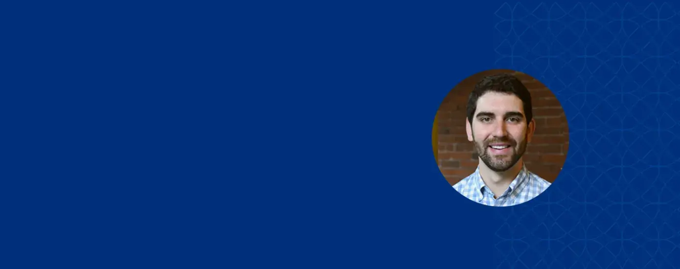 michael has a beard and moustache and wears a blue plaid shirt