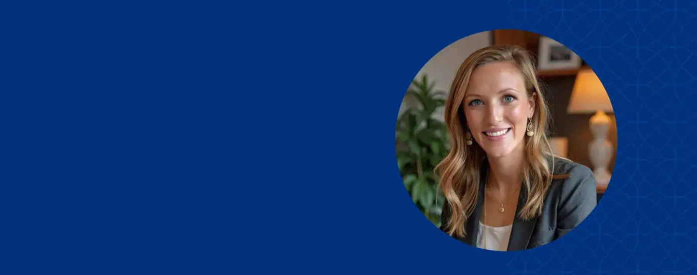 Woman with blond hair smiling and wearing gray jacket