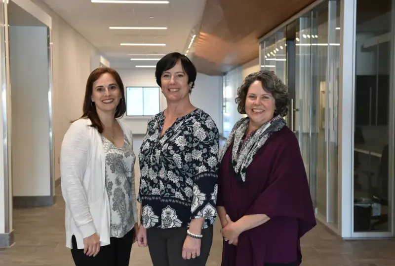 Picture of Lisa Moran, Barbara Wilson Arboleda, and Jenn Mackey standing together at IHP