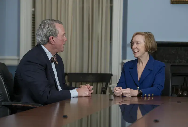 dean white and debbie burke talk across a conference room table