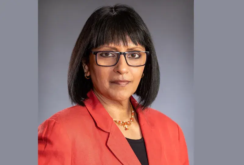 subha wears black rimmed glasses and a red blazer