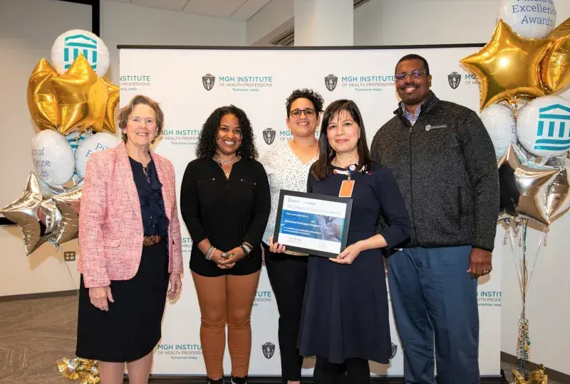 group stands next to balloons
