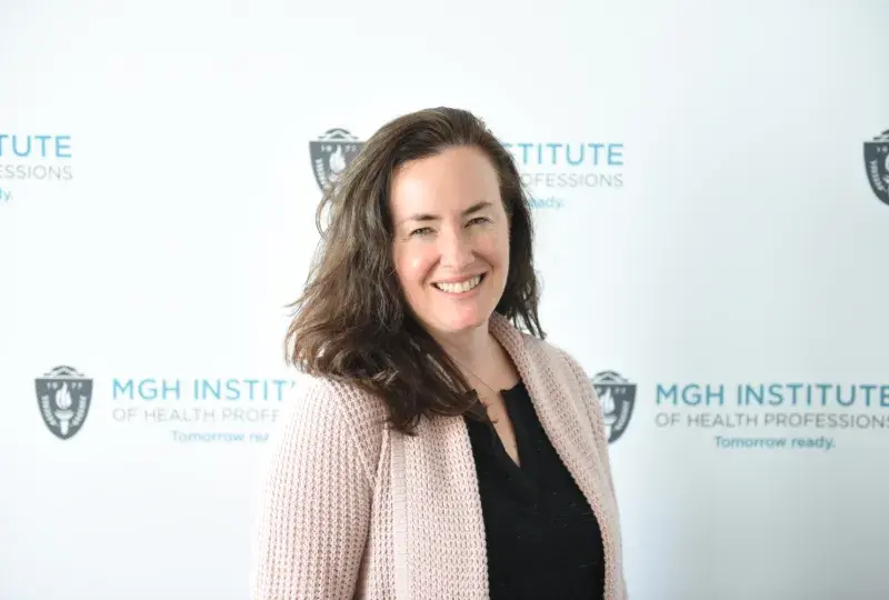 woman stands in front of banner