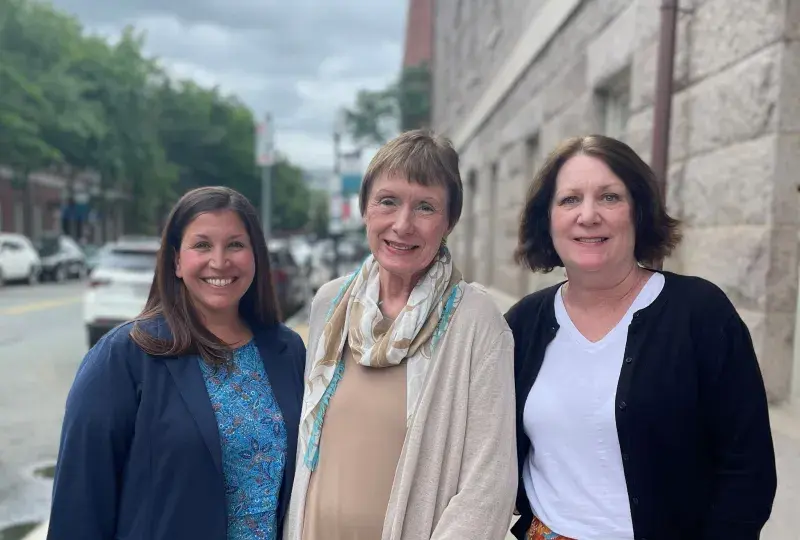 three woman standing on sidewalk