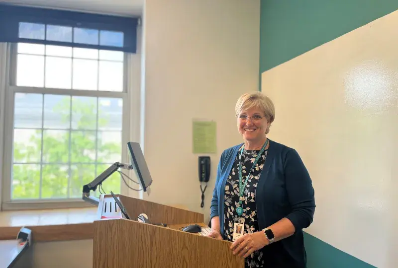 Professor Andrea Pittman stands in front of podium in classroom