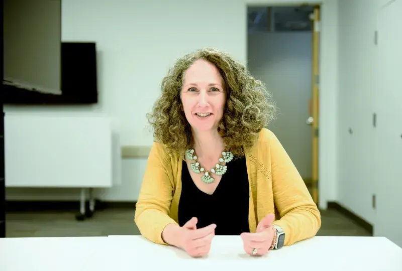 Woman wearing yellow sitting at table