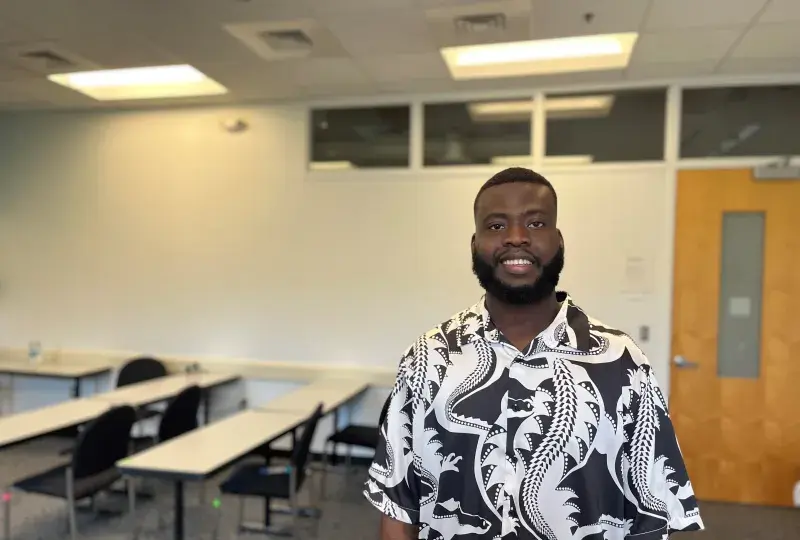 student stands in classroom