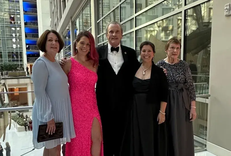 Dean Ken White stands with four women dressed up