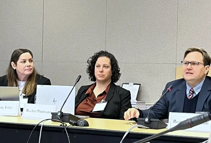 Three people testifying while sitting at a table