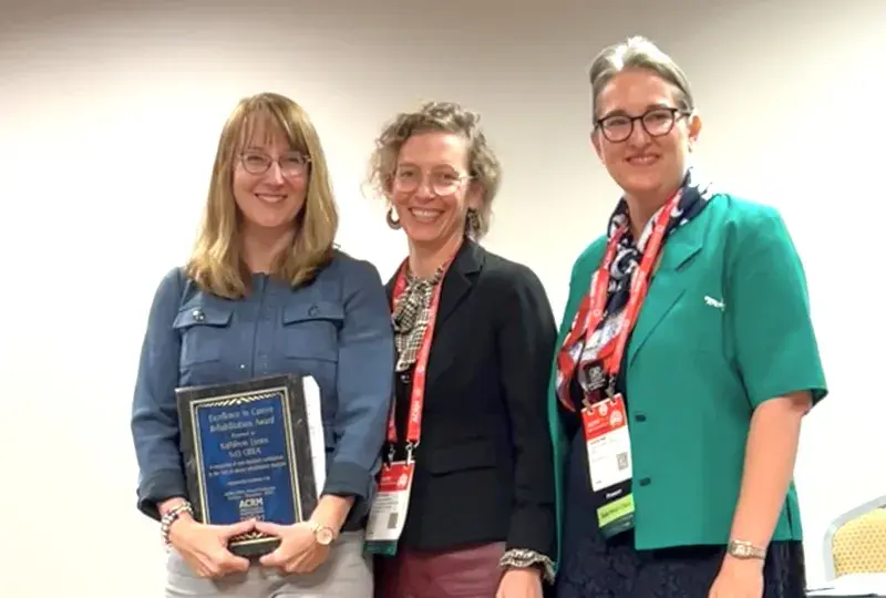 Three women standing and smiling